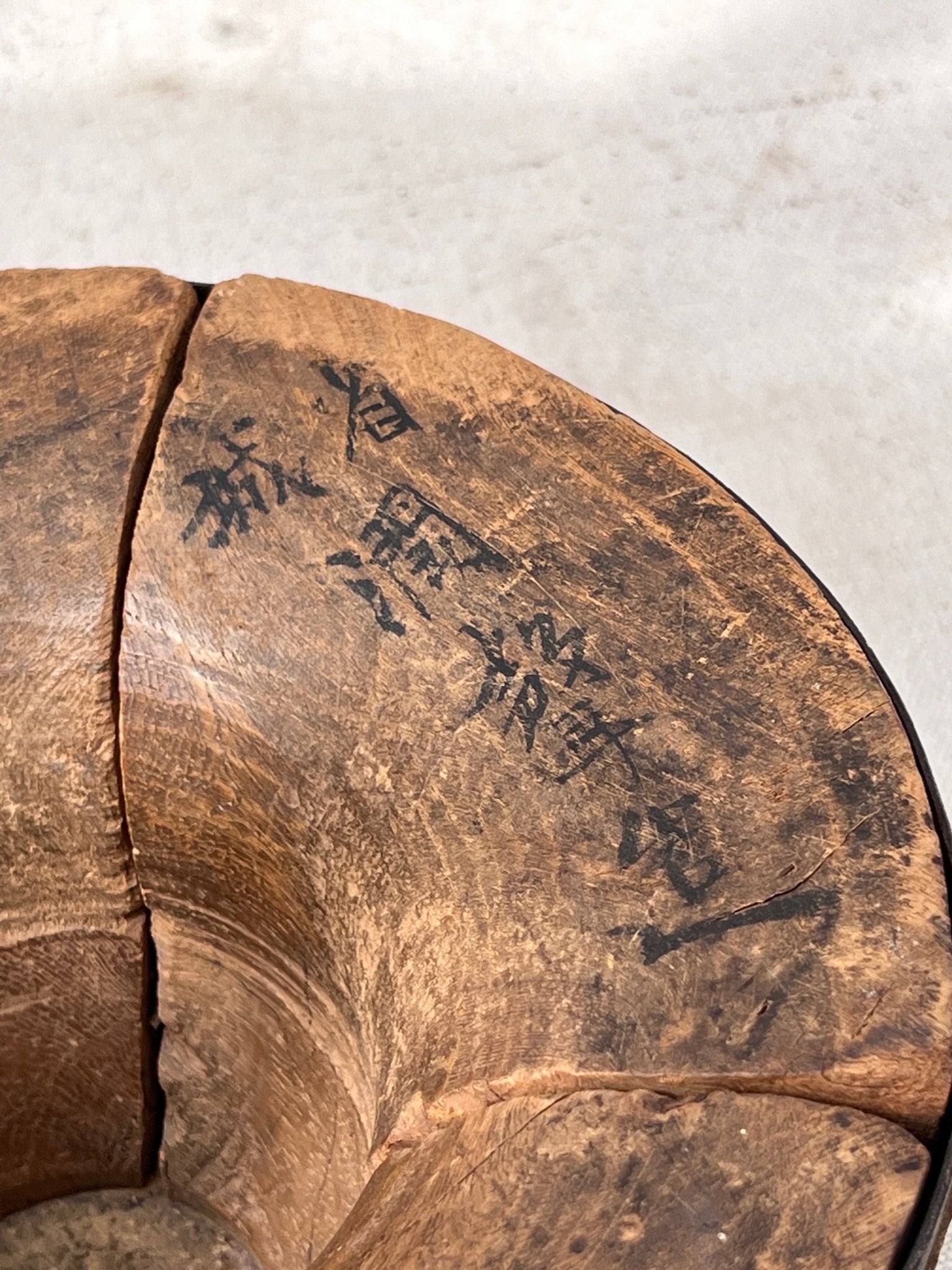 Close-up view of the Primitive Chinese Wood & Animal Skin Bowl showcasing Asian characters on the wood. hommes + gardens estudio.