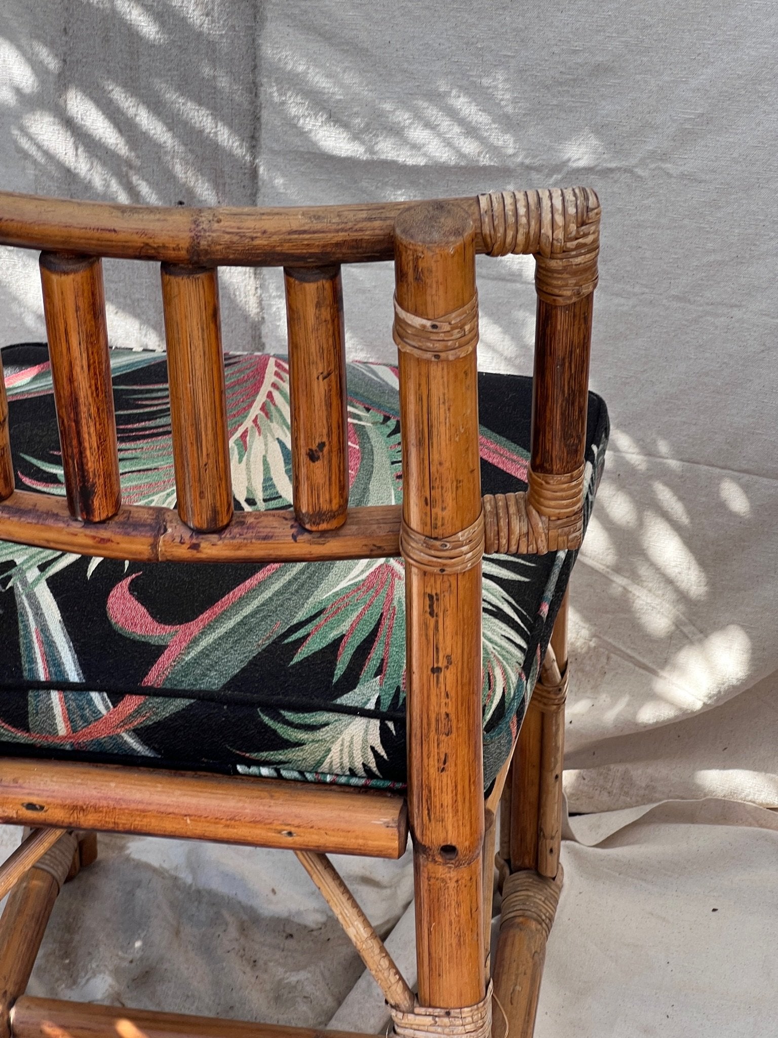 Close-up of Rattan Bistro Table with Black Glass Top showcasing Hollywood Palm upholstery, hommes + gardens estudio.