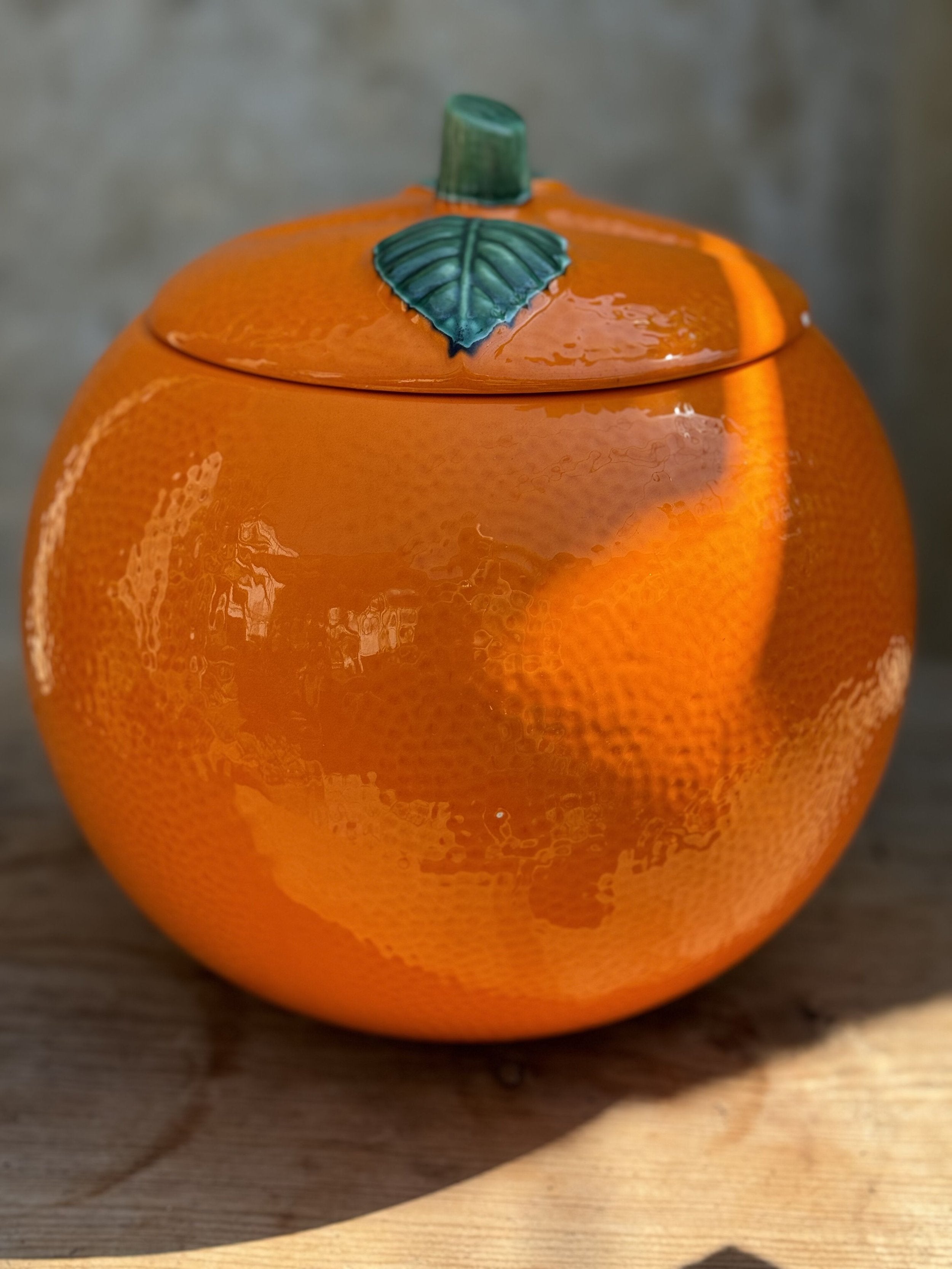 Retro Orange-Shaped Cookie Jar - Vintage Kitsch showcasing a vibrant orange design with leaf lid, perfect for vintage decor. hommes + gardens estudio.