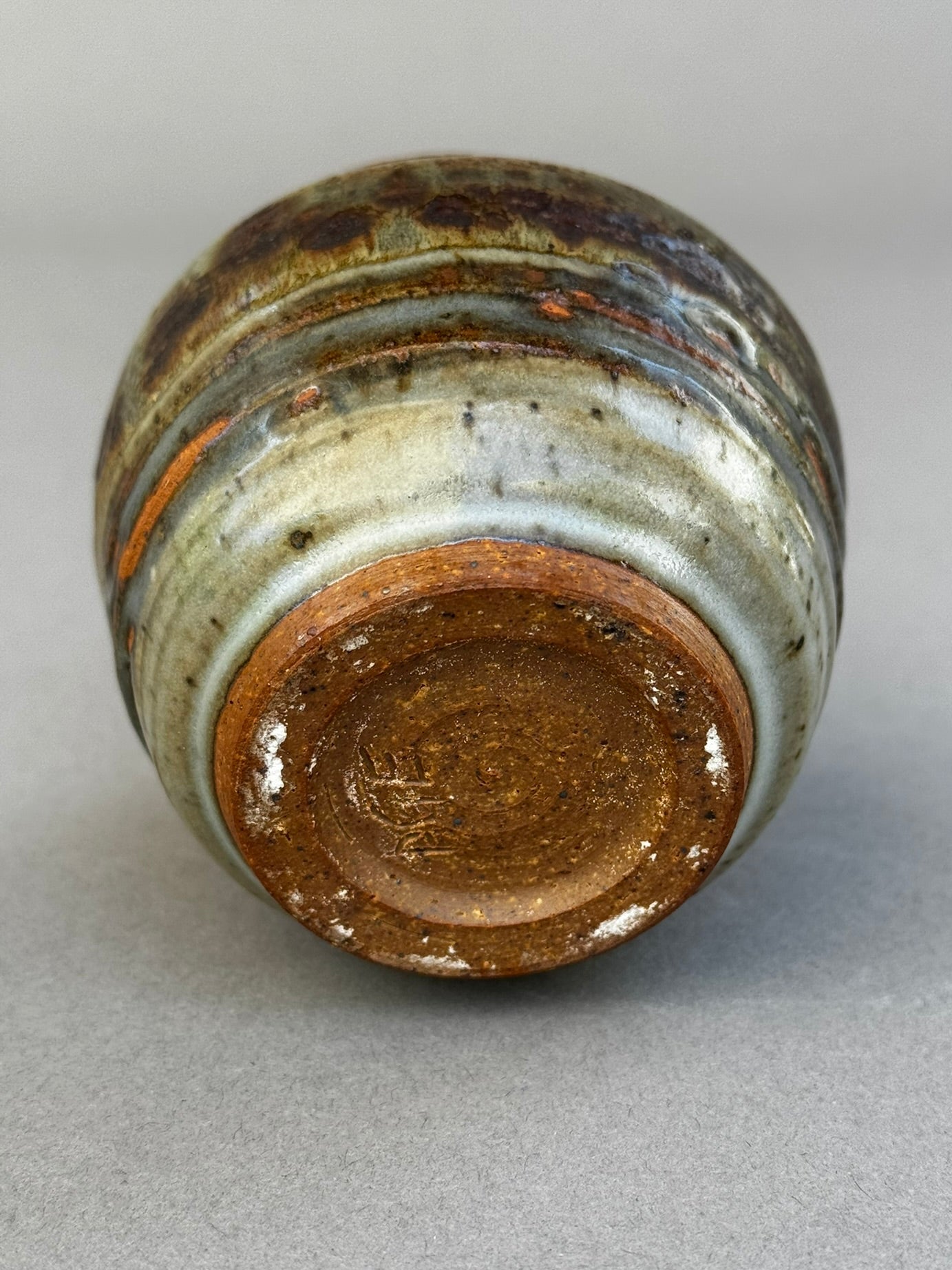 Base view of signed studio pottery urn vase by P.S.E. showing layered brown, gray, and terracotta ash glaze over stoneware clay — Hommes and Gardens, Home Decor Collection, landscape design, plant design, Landscape Architect, Interior Designer, Outdoor Living, Outdoor Decorations, Home Design, Luxury Design, Art, Furniture, Objects, Best Gifts, Nature, Backyard, Yard.