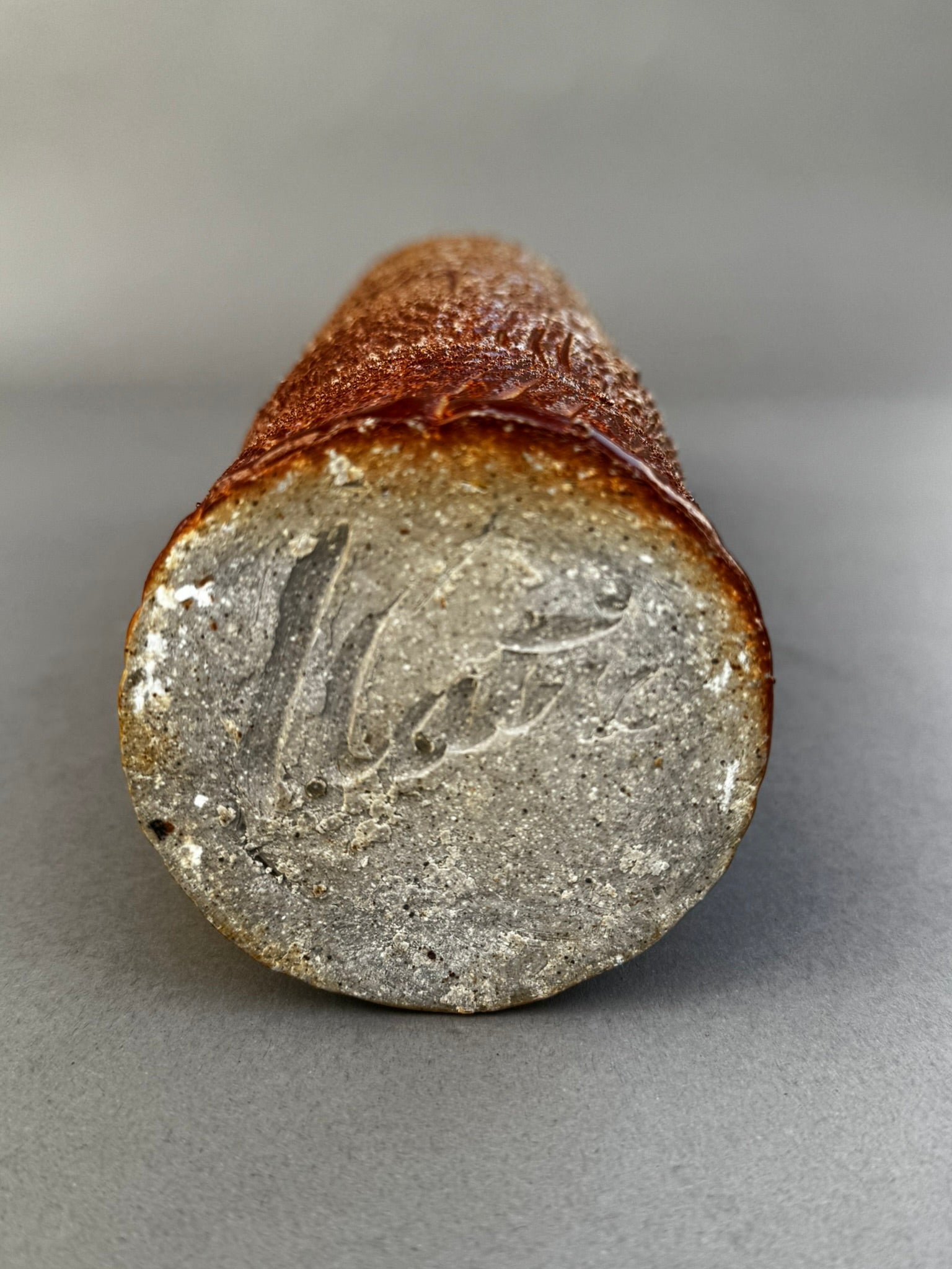 Base of tall textured studio pottery vase with glazed rim – signed ceramic art piece by hommes + gardens estudio.