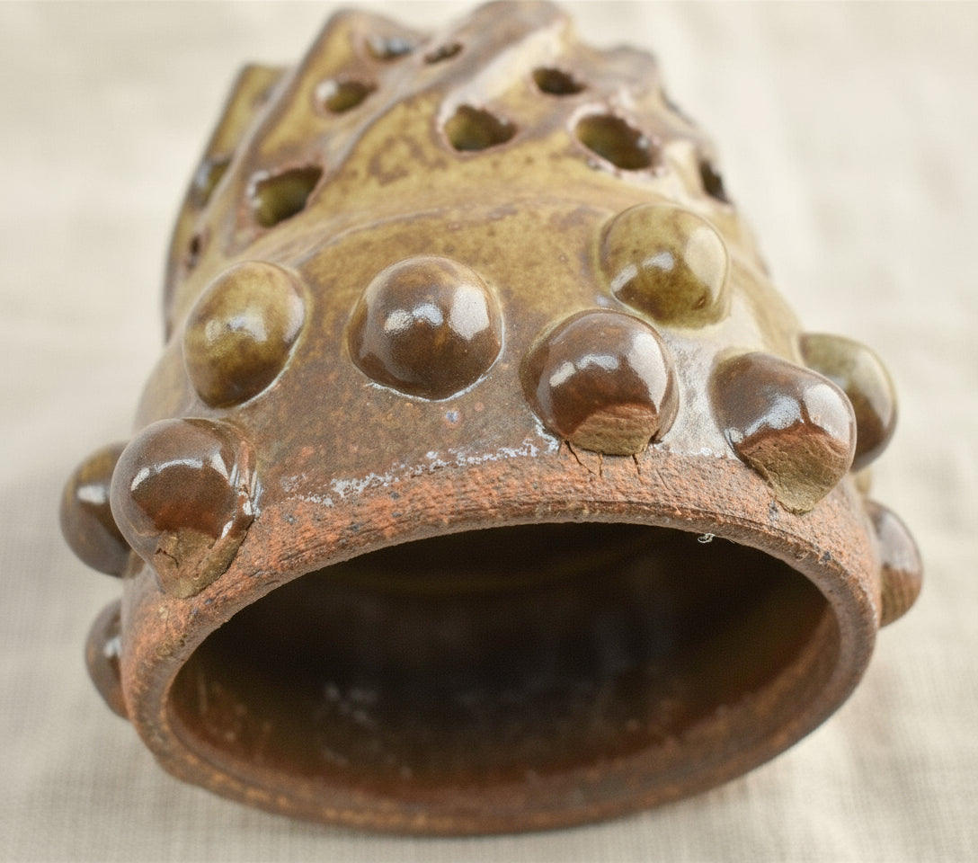 Naïve Art Pottery - Flower frog - Signed Mary, featuring an abstract round design with carved holes, handcrafted earthy tones. hommes + gardens estudio.