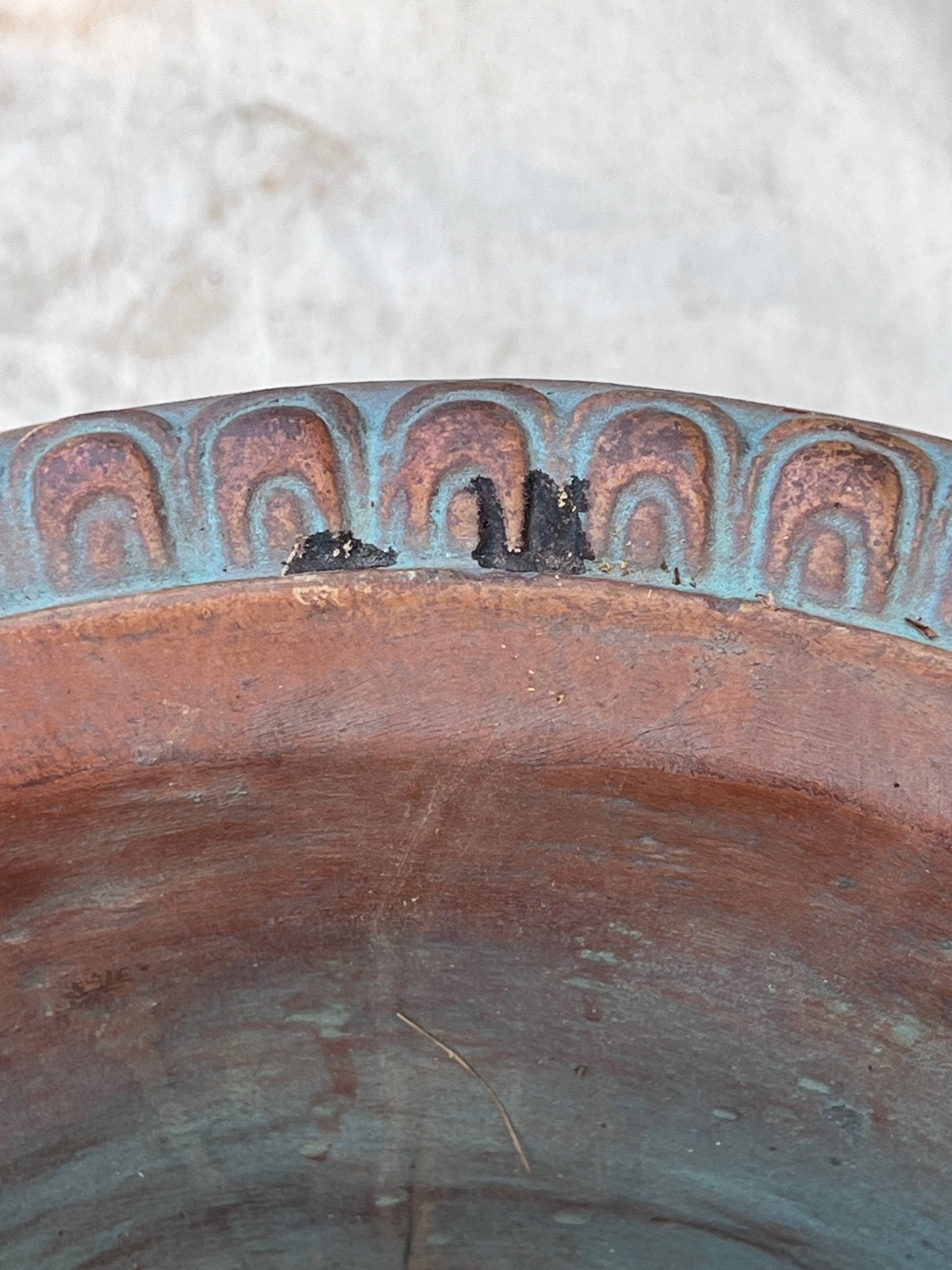 Close-up of the Silvestri Terracotta Ornate Planter (Set of 2) showcasing intricate details and blue patina accents. hommes + gardens estudio.