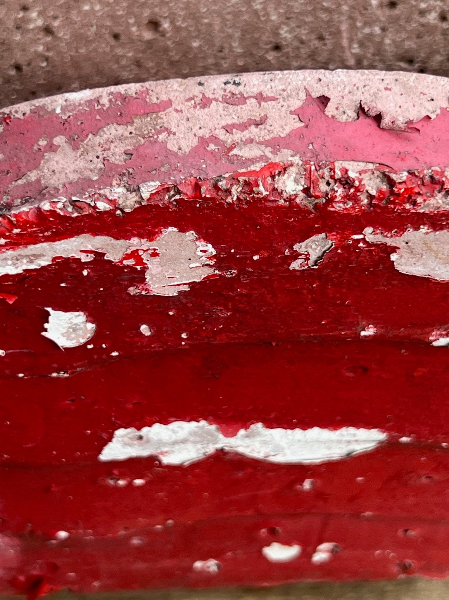 Close-up of the patina on a vintage red surface of the Willy Guhl Vintage Red Planter, showcasing its age and charm. hommes + gardens estudio.