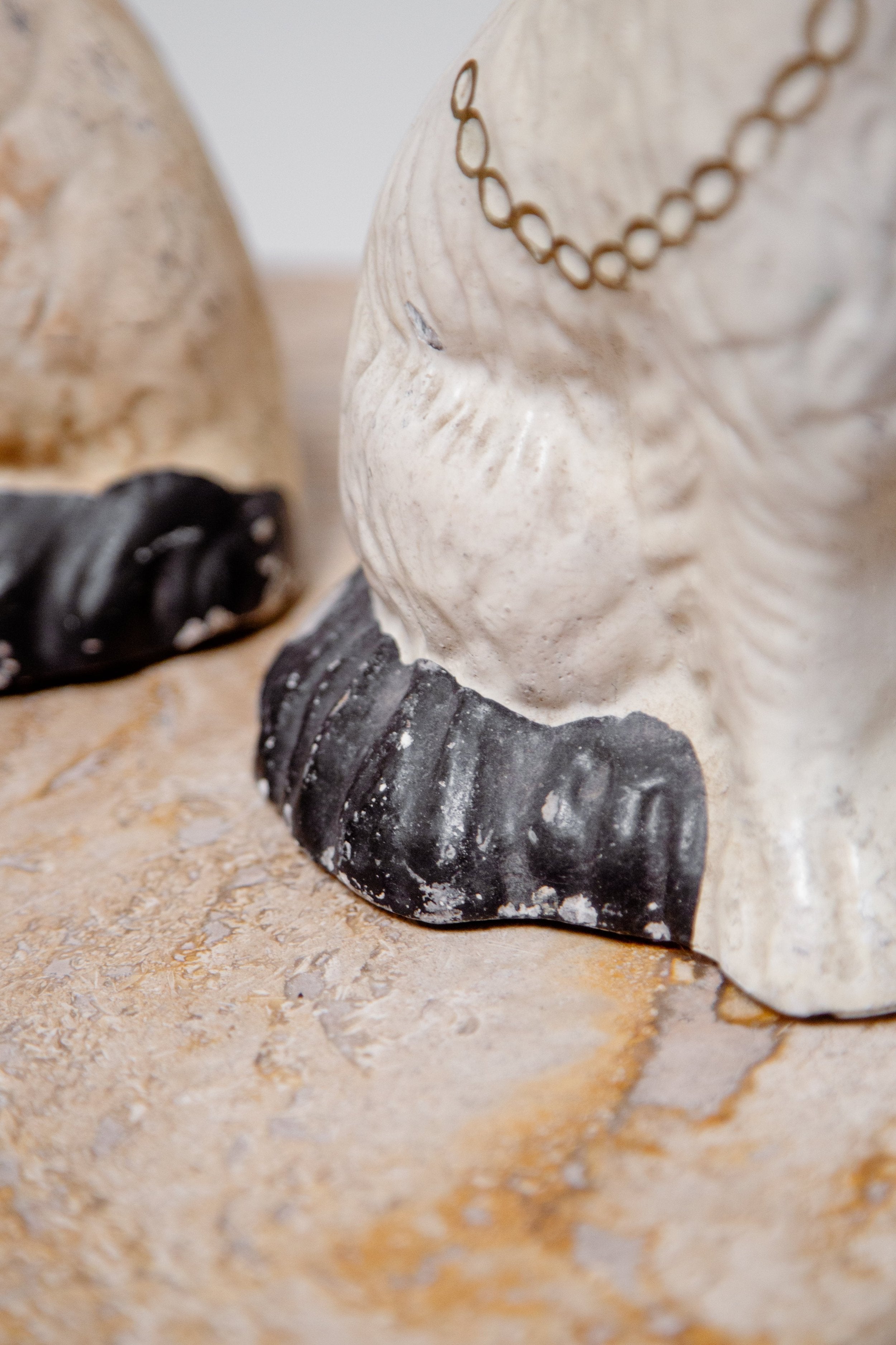 Close-up of the paws of Victorian Pair of Staffordshire Dog Figurines showcasing intricate details and craftsmanship. hommes + gardens estudio.