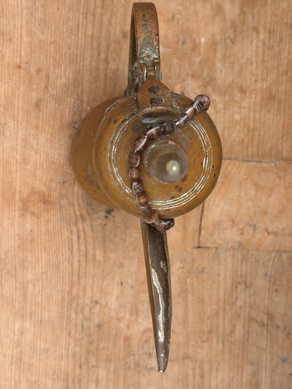 Vintage Arabic Dallah brass coffee pot with curved spout and decorative bead necklace, authentic Bedouin artifact rich in cultural heritage — Hommes and Gardens, Objects Collection, Landscape Architect, Interior Designer, Outdoor Living, Art, Furniture, Objects, Best Gifts, Nature, Backyard, Yard, Outdoor Decorations, Home Decor, Home Design, Luxury Design.