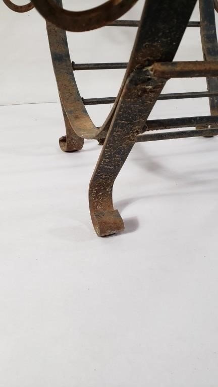 Close-up of leg detail on a VINTAGE WROUGHT IRON FIREWOOD HOLDER, showcasing its sturdy construction and rustic charm. hommes + gardens estudio.