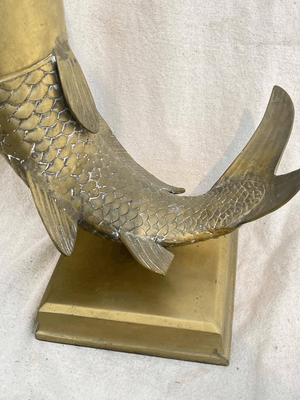 Close-up of the tail of a Solid Brass Fish Vase showcasing detailed scales and sturdy base. hommes + gardens estudio.