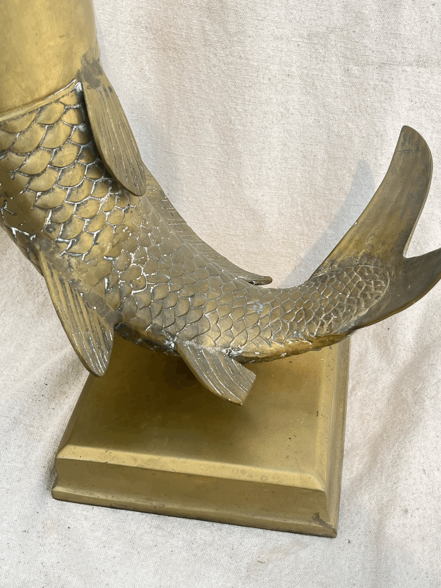 Close-up of the tail of a Solid Brass Fish Vase showcasing detailed scales and sturdy base. hommes + gardens estudio.