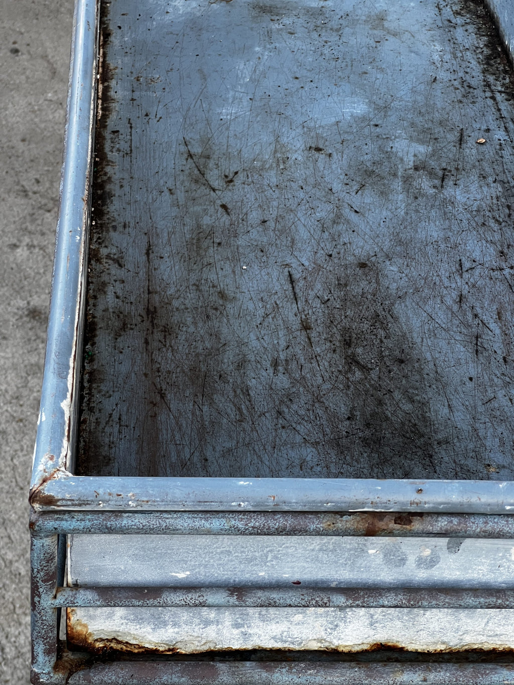 Close-up view of a weathered metal surface showcasing an aged design, ideal for a Vintage Arras Style Tall Weathered Metal Plant Stand, hommes + gardens estudio.