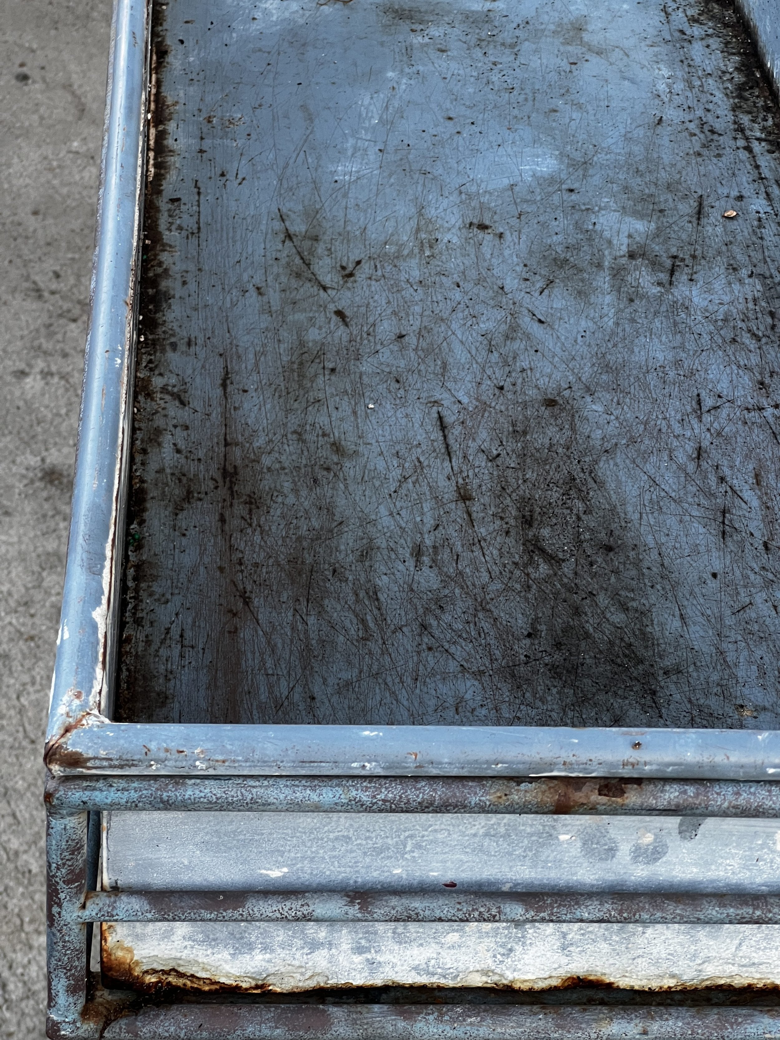 Close-up view of a weathered metal surface showcasing an aged design, ideal for a Vintage Arras Style Tall Weathered Metal Plant Stand, hommes + gardens estudio.