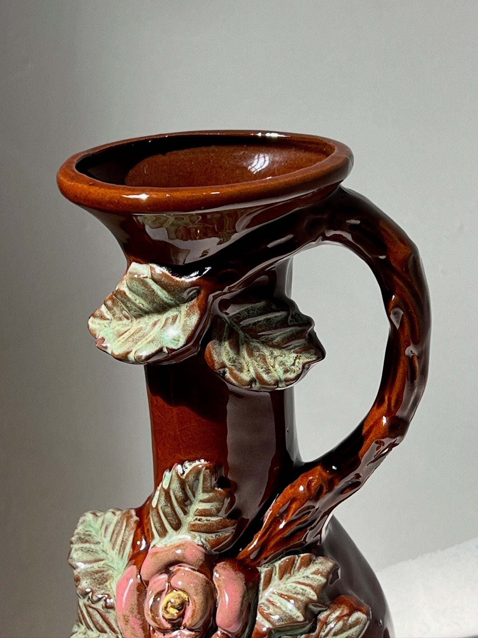 Small antique ceramic vase with 3D floral motifs showcasing intricate floral designs and detailed handles. hommes + gardens estudio.