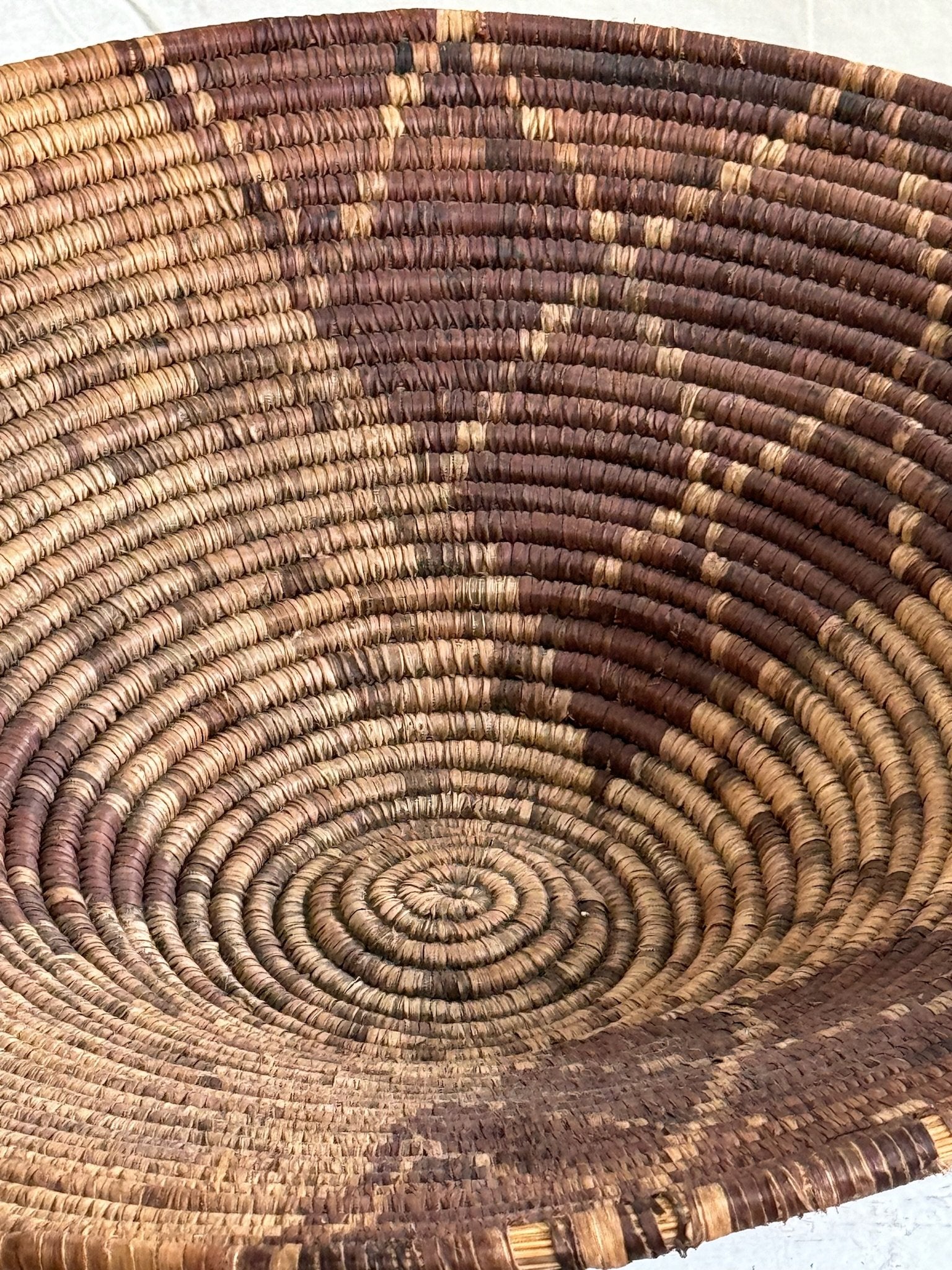 Vintage Round  Rattan Coiled Boho Woven Basket showcasing intricate weaving and two-tone design, 16” D. hommes + gardens estudio.