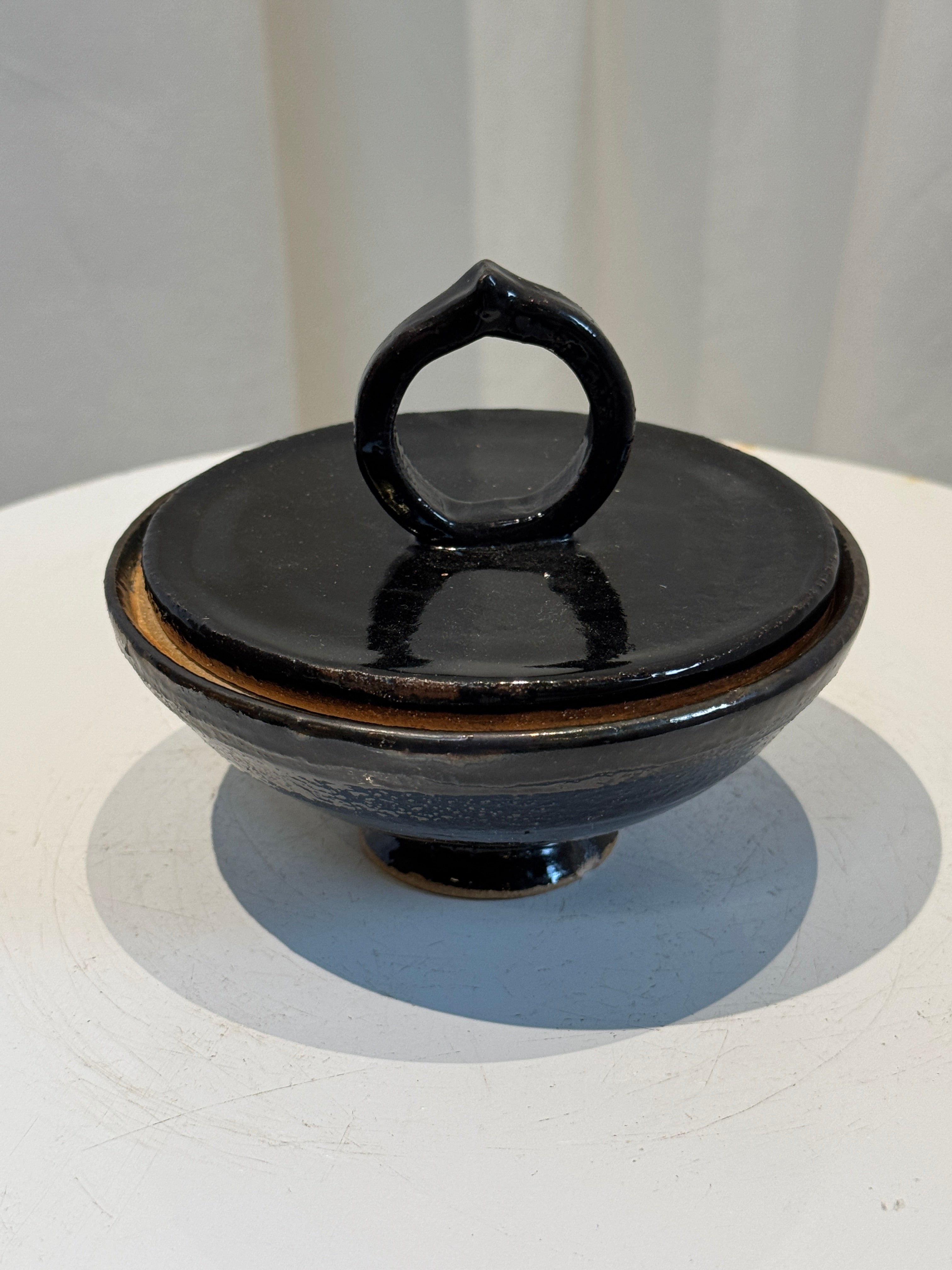 Vintage handmade ceramic lidded bowl with deep black glaze and ring handle, elegant rustic collectible ideal for functional or decorative use — Hommes and Gardens, Catchall Collection, Landscape Architect, Interior Designer, Outdoor Living, Art, Furniture, Objects, Best Gifts, Nature, Backyard, Yard, Outdoor Decorations, Home Decor, Home Design, Luxury Design.