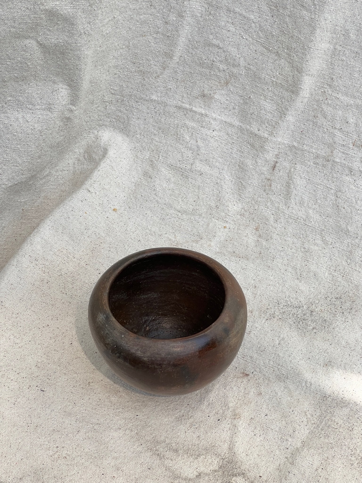 Small Vintage Dark Brown Clay Vase with organic character and pebble shape, perfect for home decor. hommes + gardens estudio.