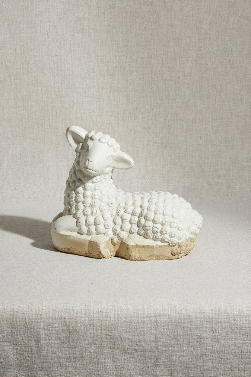 Vintage Laying Lamb Stoneware Figurine rests elegantly, showcasing intricate details of its serene design. hommes + gardens estudio.