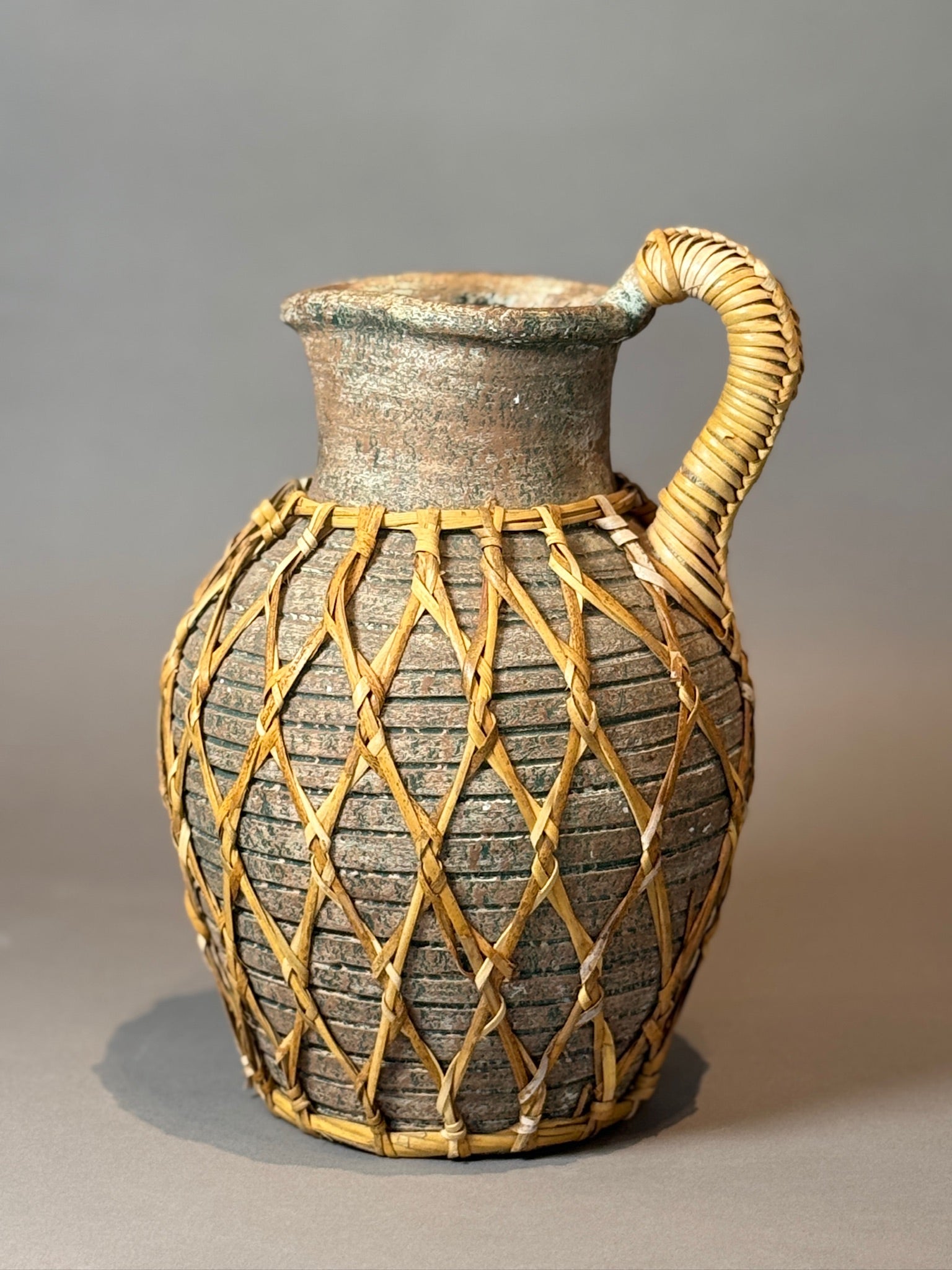 Vintage Woven Rattan Wrapped Vessel featuring a unique woven design and rustic charm, perfect for home decor. hommes + gardens estudio.