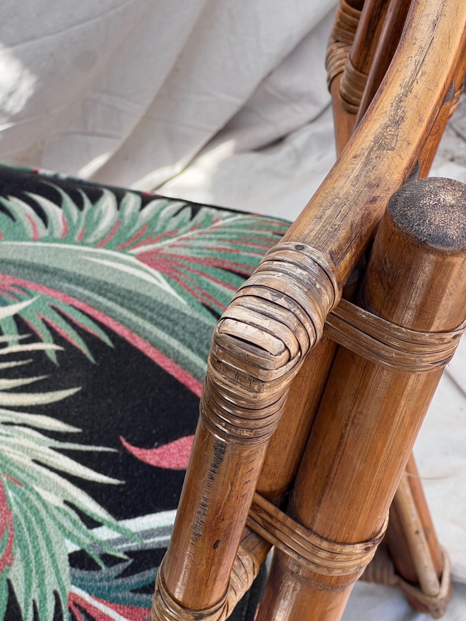 Close-up of Rattan Bistro Table with Black Glass Top showcasing the chair's detailed upholstery and craftsmanship. hommes + gardens estudio.