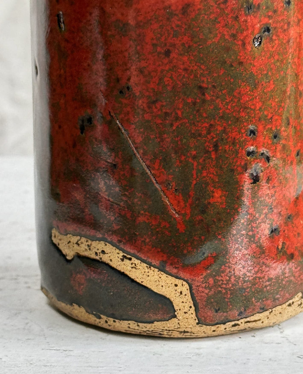 Close-up of the base of a Vintage Signed Handmade Glazed Ceramic Vase with stunning red slip glaze. hommes + gardens estudio.