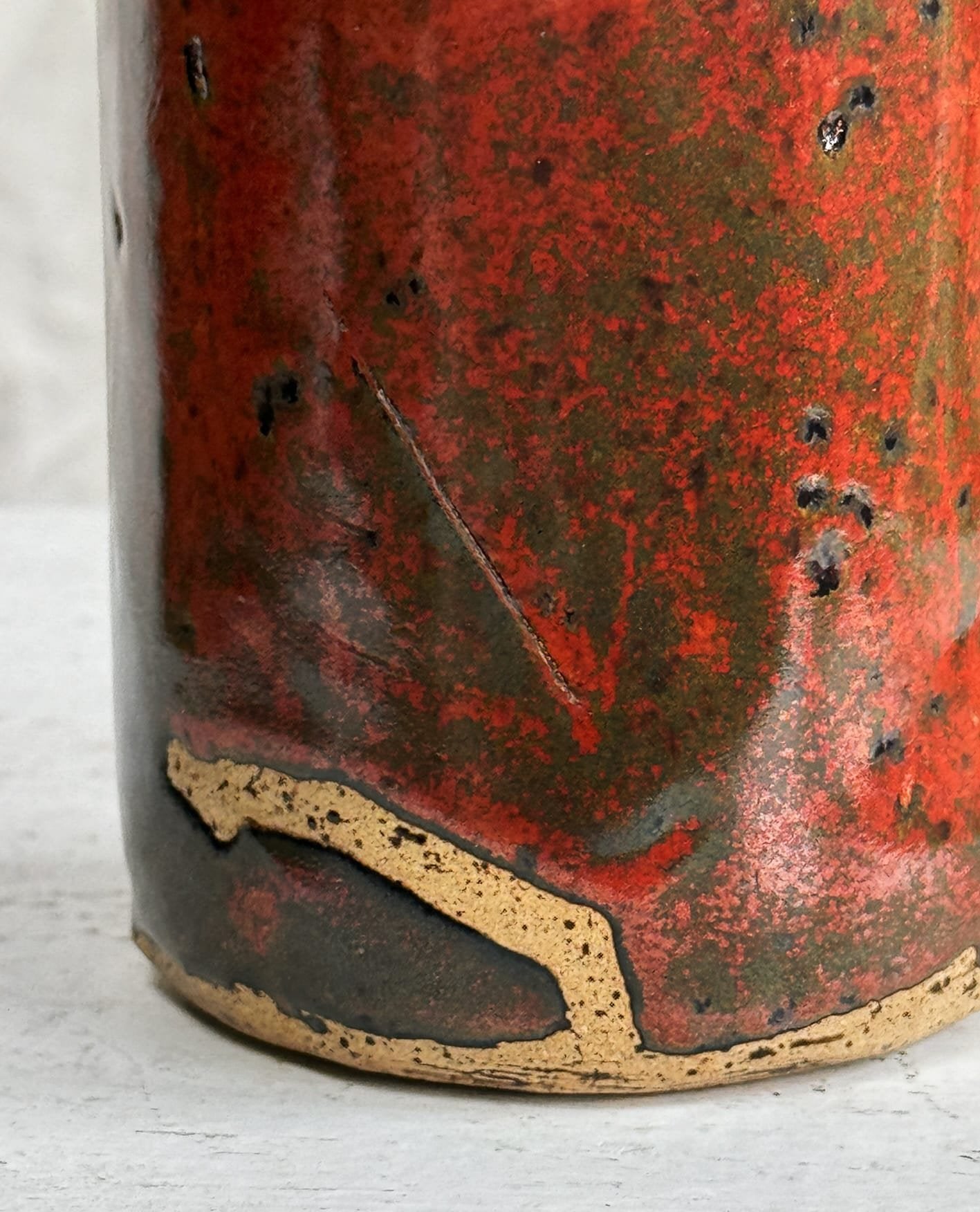 Close-up of the base of a Vintage Signed Handmade Glazed Ceramic Vase with stunning red slip glaze. hommes + gardens estudio.