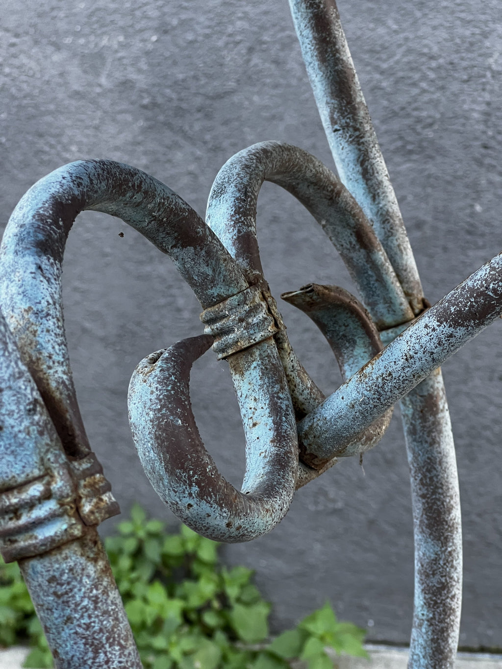 Close-up of intricate details on a Vintage Arras Style Tall Weathered Metal Plant Stand. hommes + gardens estudio.