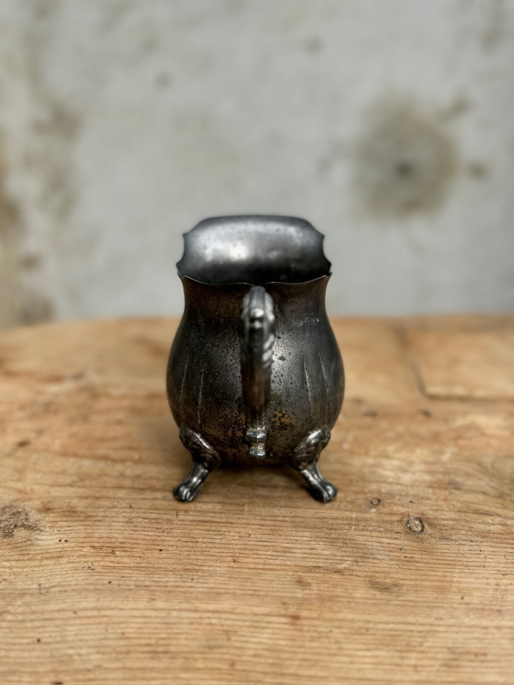 Vintage Silver-Plated Footed Creamer with Handle on wooden surface. Elegant design for tea or coffee settings. hommes + gardens estudio.