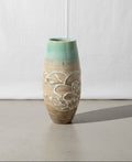 Vintage stamp-signed ceramic vase with light blue and light brown hues and floral designs, perfect for adding elegance to any decor. hommes + gardens estudio.
