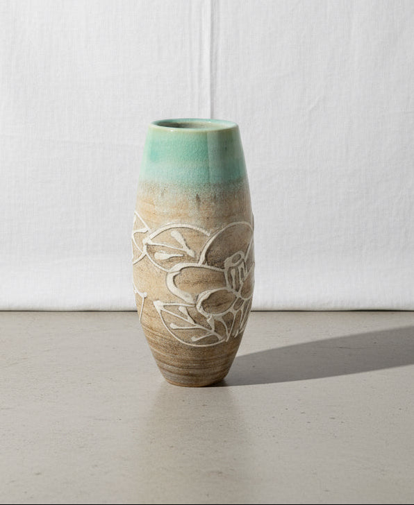 Vintage stamp-signed ceramic vase with light blue and light brown hues and floral designs, perfect for adding elegance to any decor. hommes + gardens estudio.