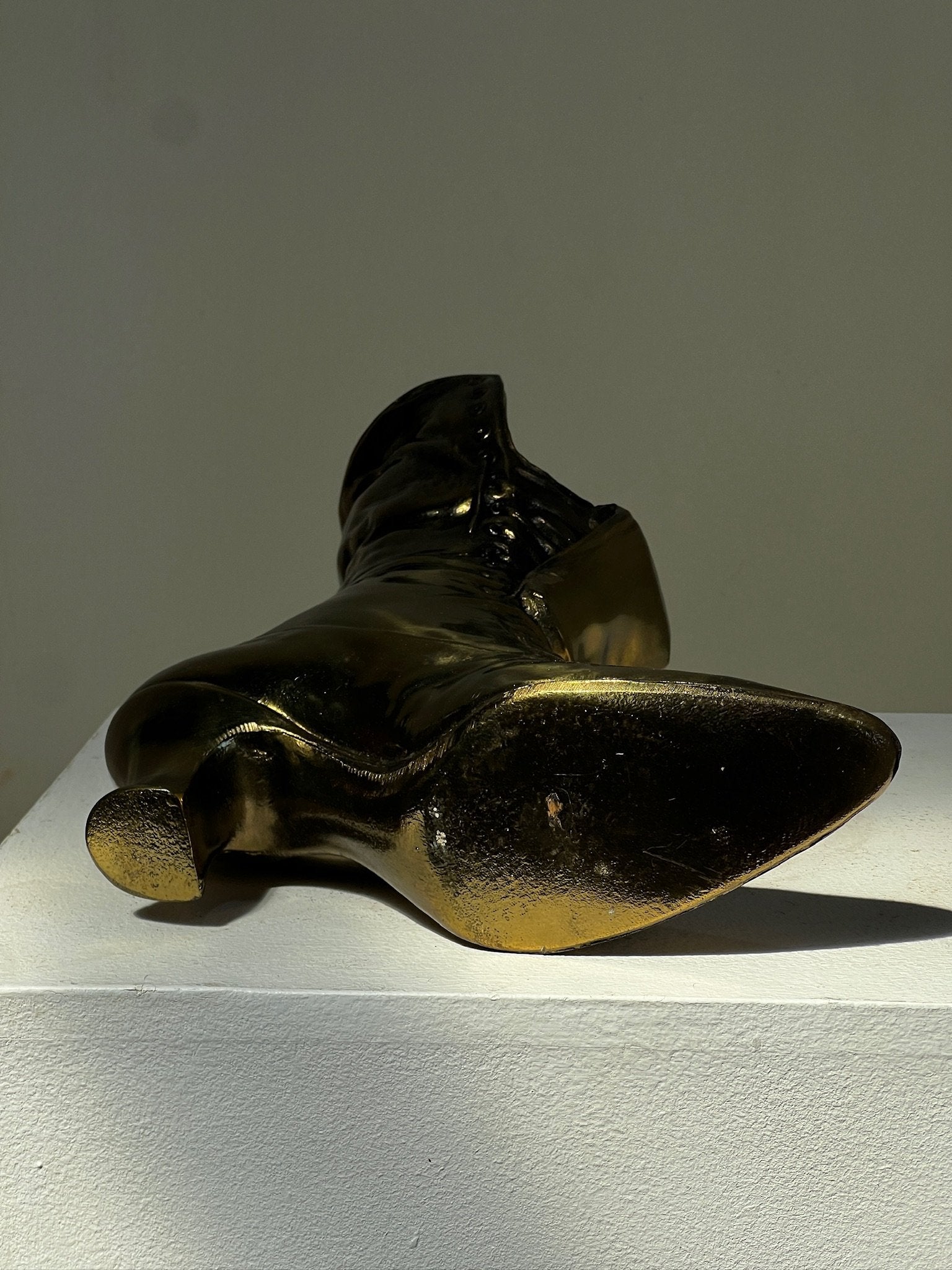 Vintage Victoria style cast brass boot window planter displayed elegantly on a pedestal, perfect for vintage decor. hommes + gardens estudio.