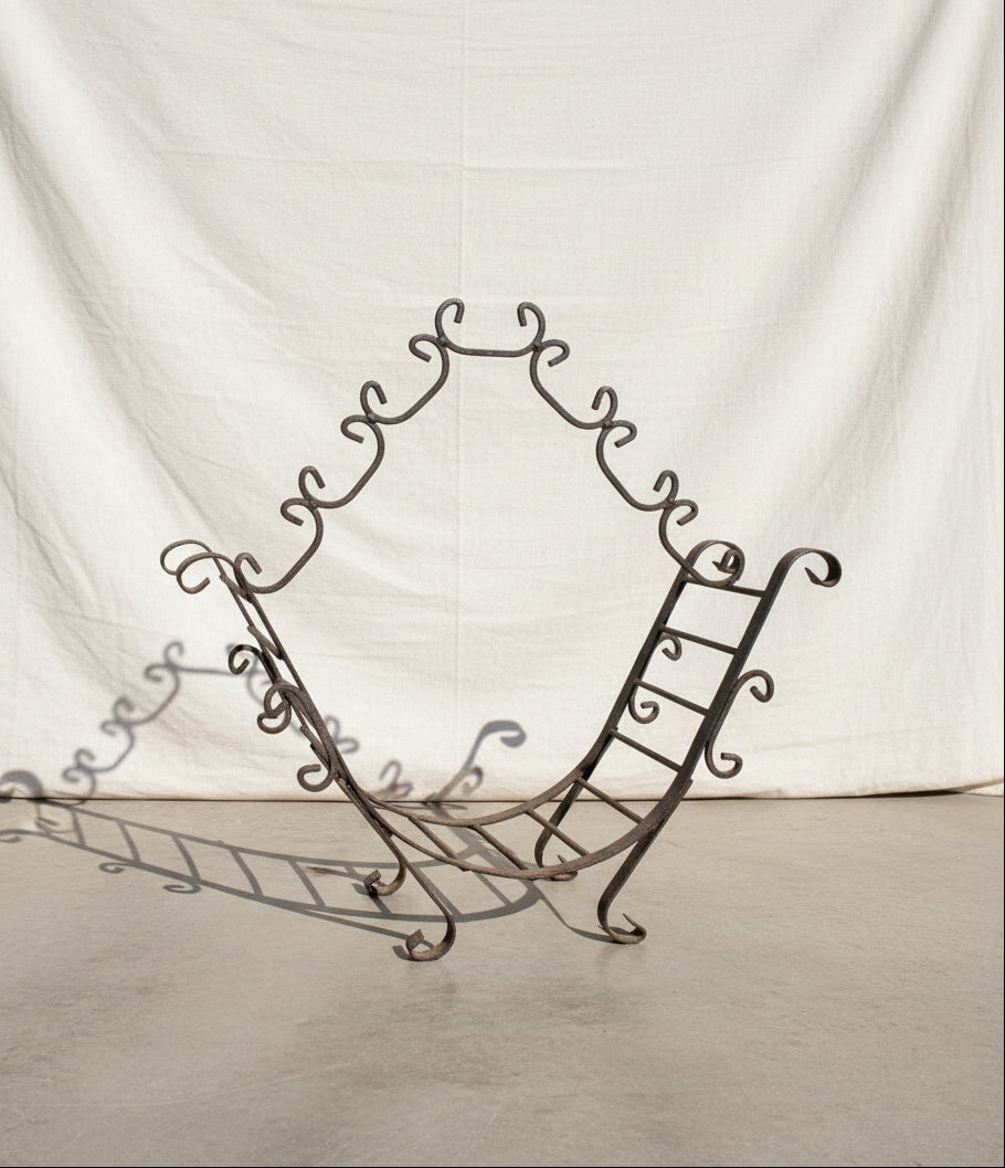 Vintage Wrought Iron Firewood Holder with decorative design on a neutral background, perfect for rustic decor, hommes + gardens estudio.