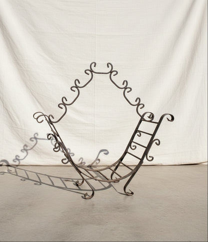 Vintage wrought iron firewood holder featuring an open frame and sturdy construction, combining rustic charm with timeless functionality for home interiors — Hommes and Gardens, Home Decor Collection, Firewood Holders, Decorative Objects, Vintage Ironwork, Rustic Fireplace Accessories, Antique Metal Decor, Classic Home Styling, Hearth Design Accent.