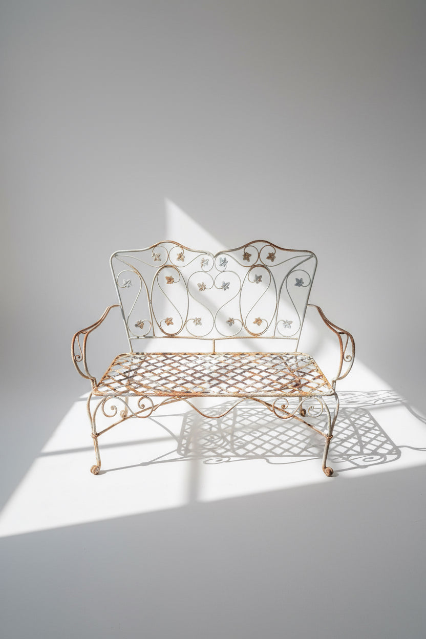 Vintage Wrought Iron Garden Bench with ornate scroll and foliage design, perfect for outdoor spaces. hommes + gardens estudio.