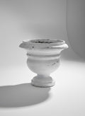 White decorative urn on a light gray background